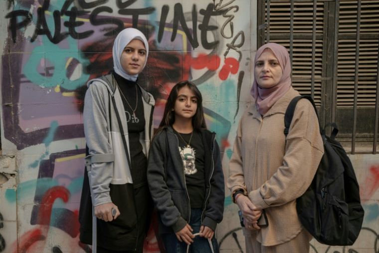 Les réfugiées palestiniennes Raghad al-Fara, à gauche et Argwan al-Fara, au centre, et leur mère Shadia al-Fara, à droite, à Athènes le 24 novembre 2025 ( AFP / Angelos TZORTZINIS )