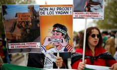 (ARCHIVES) Une personne brandit une pancarte sur laquelle on peut lire « Non au projet de loi Yadan » alors que des manifestants participent à un rassemblement contre ce projet de loi, qui vise à lutter contre les nouvelles formes d'antisémitisme, à Paris, le 12 avril 2026. ( AFP / Ian LANGSDON )