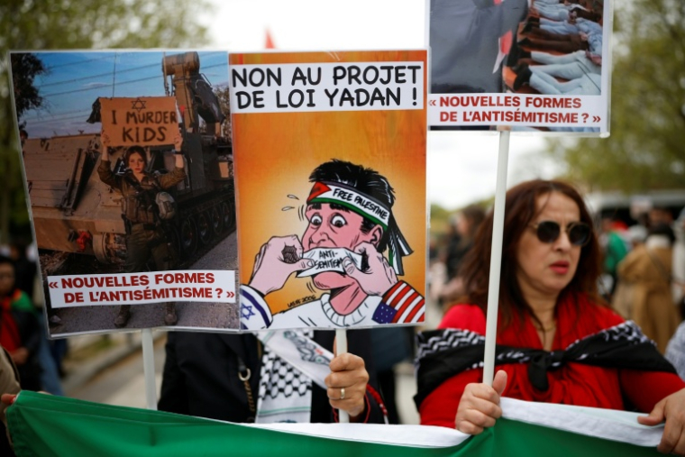 (ARCHIVES) Une personne brandit une pancarte sur laquelle on peut lire « Non au projet de loi Yadan » alors que des manifestants participent à un rassemblement contre ce projet de loi, qui vise à lutter contre les nouvelles formes d'antisémitisme, à Paris, le 12 avril 2026. ( AFP / Ian LANGSDON )