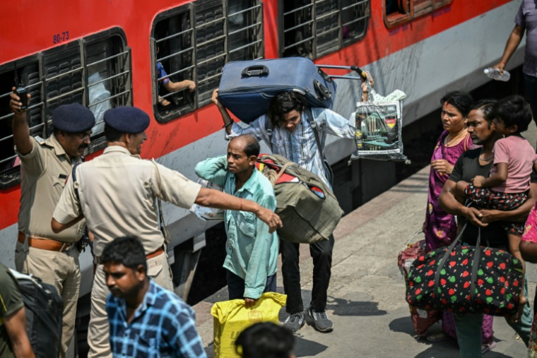 Des habitants tentent de monter dans un train à la gare de Jammu, le 10 mai 2025 au Cachemire indien ( AFP / Money SHARMA )