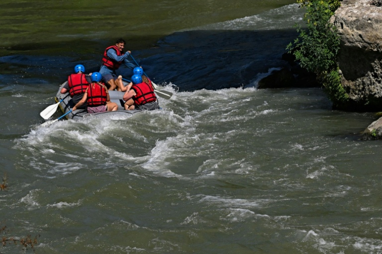 Des personnes naviguent en canot pneumatique sur le Tibre, sur un tronçon du fleuve situé entièrement dans la zone urbaine du centre de Rome, le 14 août 2026 ( AFP / Andreas SOLARO )