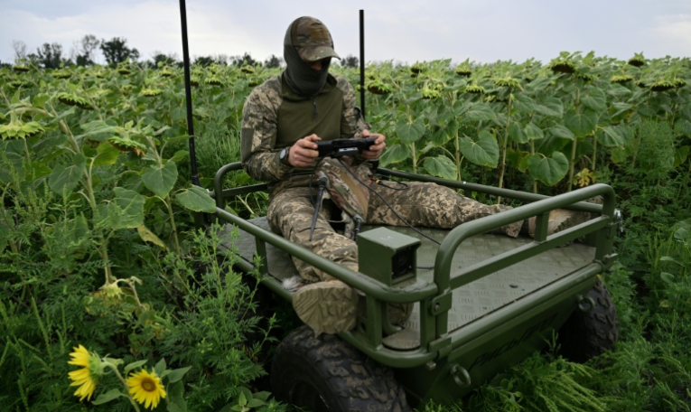 Un soldat ukrainien fait une démonstration de robot piloté à distance permettant d'évacuer des soldats blessés du front, dans l'est de l'Ukraine, le 11 août 2025 ( AFP / Genya SAVILOV )