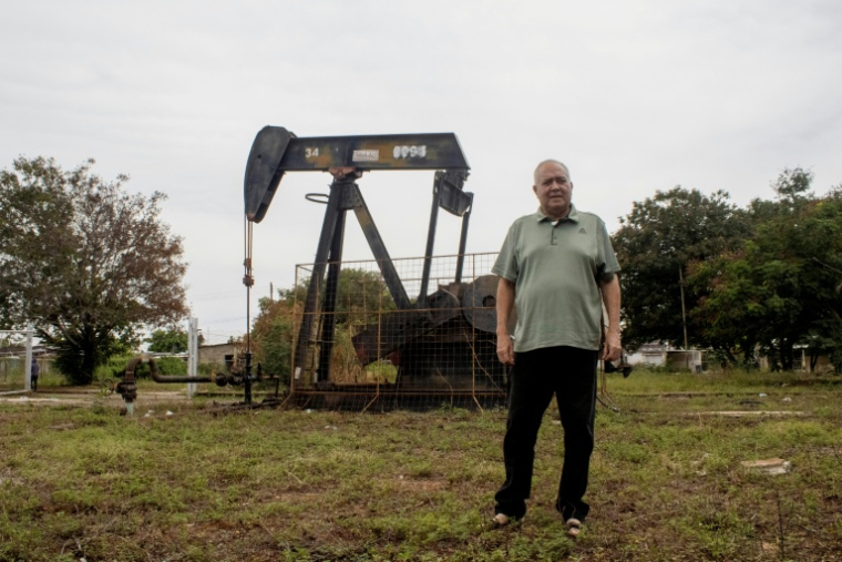 José Gregorio pose devant un chevalet de pompage à Bachaquero, près du lac de Maracaibo, berceau de l'exploitation pétrolière vénézuélienne ( AFP / Margioni BERMÚDEZ )
