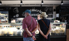 Des clients se font servir chez un fromager au marché d'Andernos-les-Bains, en Gironde, le 1er août 2026 ( AFP / ROMAIN PERROCHEAU )