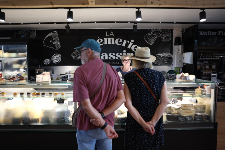 Des clients se font servir chez un fromager au marché d'Andernos-les-Bains, en Gironde, le 1er août 2026 ( AFP / ROMAIN PERROCHEAU )