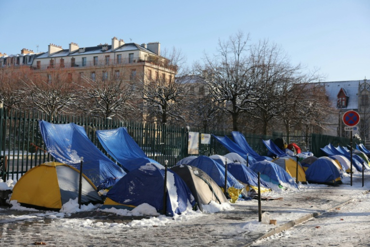 Des tentes de jeunes migrants près du Pont-Marie, dans le coeur historique de Paris enneigé, le 6 janvier 2026  ( AFP / Thomas SAMSON )