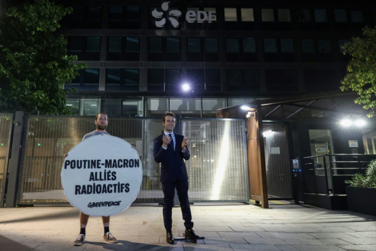 Un militant de Greenpeace au côté de la statue de cire d'Emmanuel Macron, volée la veille au musée Grévin, lors d'une action devant le siège d'EDF, à Paris le 3 juin 2025 ( AFP / Xavier GALIANA )