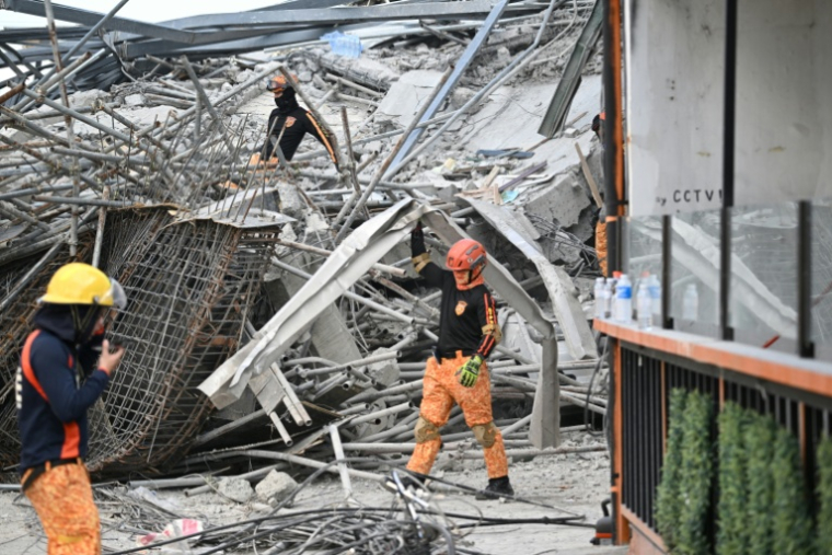 Des sauveteurs sur le site de l'effondrement d'un immeuble en construction à Angeles, aux Philippines, le 24 mai 2026 ( AFP / Ted ALJIBE )
