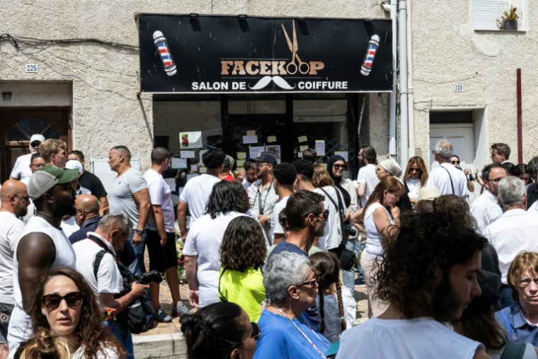 Des personnes rassemblées devant le salon de coiffure où le Tunisien Hichem Miraoui travaillait, avant une marche blanche pour lui rendre hommage, le 8 juin 2025 à Puget-sur-Argens, dans le Var ( AFP / Miguel MEDINA )