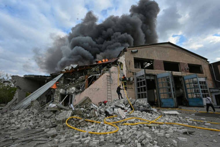 Des pompiers ukrainiens luttent contre un incendie dans un atelier de réparation automobile causé par une frappe russe à Karkhiv, en Ukraine, le 5 octobre 2026 ( AFP / SERGEY BOBOK )
