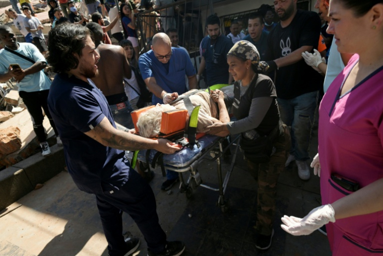 Une femme sortie des décombres est transportée par les secouristes sur un brancard, après un puissant tremblement de terre, à Cali en Colombie le 10 août 2026 ( AFP / JOAQUIN SARMIENTO )