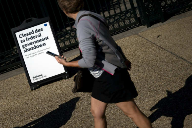 Une femme passe devant une pancarte de la National Gallery of Art à Washington, annonçant que le musée est fermé en raison du blocage budgétaire en cours au Congrès, le 6 octobre 2025 ( AFP / Brendan Smialowski )