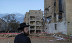 Un juif orthodoxe israélien regarde le site d'une frappe de missile iranien à Arad, dans le sud d'Israël, le 22 mars 2026 ( AFP / Ilia YEFIMOVICH )