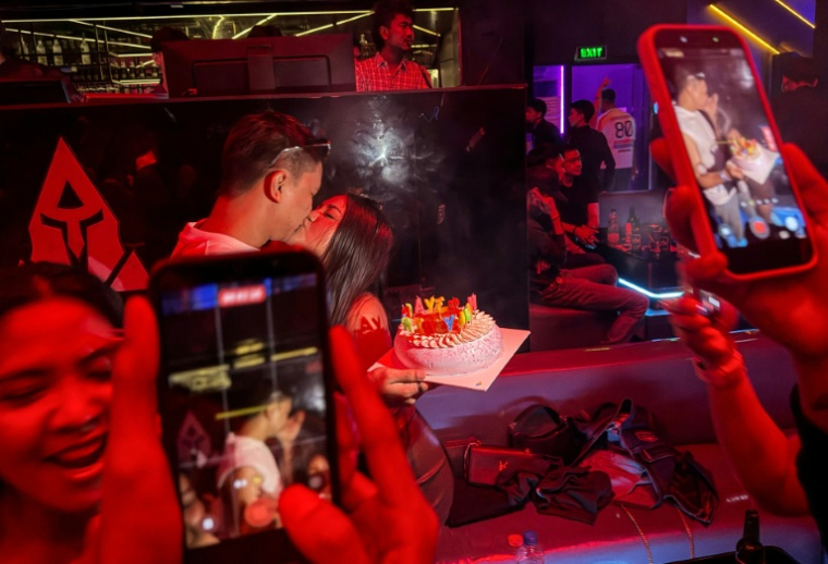 Cette photo prise tôt dans la matinée du 16 mai 2026 montre des personnes célébrant un anniversaire dans une discothèque de Rangoun.  ( AFP / Sai Aung MAIN )