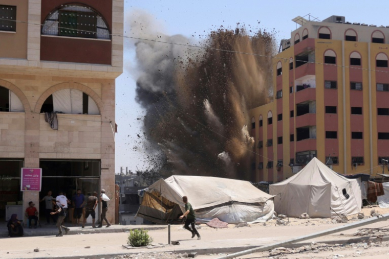 Des Palestiniens se précipitent pour se mettre à l'abri après qu'une frappe israélienne a touché un immeuble à Jabalia, dans le nord de la bande de Gaza, le 20 août 2025 ( AFP / BASHAR TALEB )