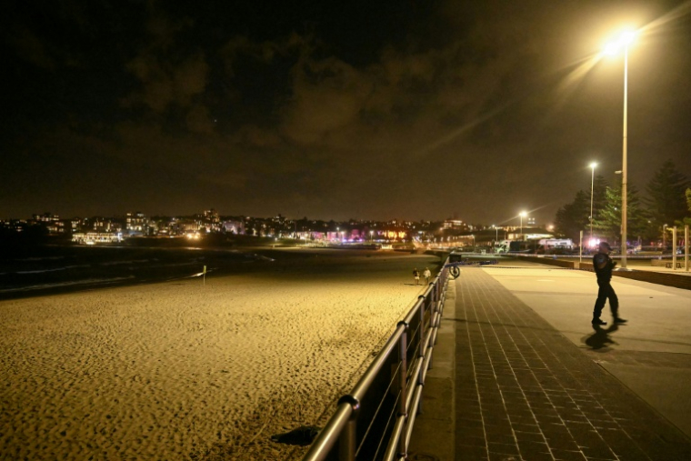 Un policier en patrouille après une attaque par balles qui a fait neuf morts sur la plage de Bondi à Sydney, le 14 décembre 2025 ( AFP / Saeed KHAN )