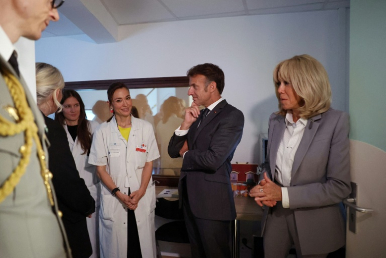 Le président Emmanuel Macron (c) et son épouse Brigitte Macron (d) rencontrent la pédiatre Tania Ikowsky lors d'une visite à l'unité UAPED (Unité d'Accueil Pédiatrique Enfant en Danger), une structure hospitalière spécialisée dans la prise en charge des enfants victimes de violence, de maltraitance ou de négligence, à l'hôpital Robert-Debré à Paris, le 10 juin 2026 ( POOL / Gonzalo Fuentes )