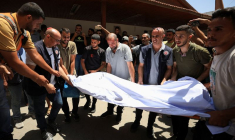 Des personnes transportent le corps du chrétien palestinien Saad Salama, tué dans une frappe israélienne sur l'église de la Sainte-Famille