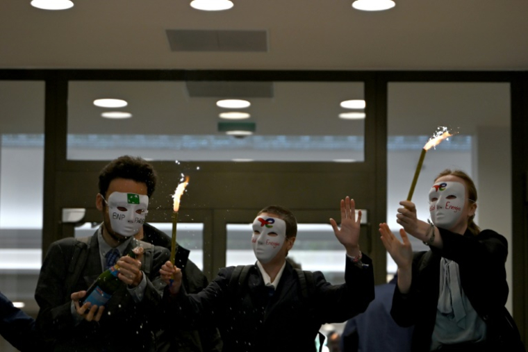 Des membres d'Extinction Rebellion (XR) manifestent devant les bureaux de la banque BNP Paribas, avant l'assemblée générale ordinaire et extraordinaire des actionnaires de TotalEnergies, le 23 mai 2025 à Paris ( AFP / Leo VIGNAL )
