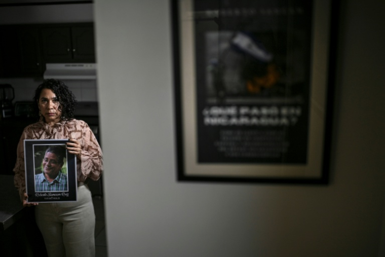 Claudia Vargas, veuve du militaire à la retraite Roberto Samcam, pose avec une photo de son mari à San Jose le 9 mai 2026 ( AFP / MARTIN BERNETTI )