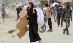 Des Palestiniens transportent des fournitures d'aide qu'ils ont reçues de la Fondation humanitaire de Gaza (GHF), soutenue par les États-Unis, dans le centre de la bande de Gaza.