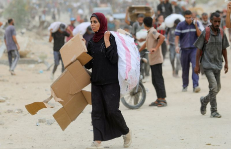 Des Palestiniens transportent des fournitures d'aide qu'ils ont reçues de la Fondation humanitaire de Gaza (GHF), soutenue par les États-Unis, dans le centre de la bande de Gaza.