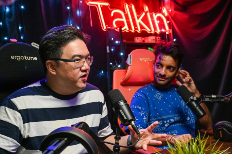 Les animateurs de "Yah Lah Bu", Terence Chia (g) et Haresh Tilani (d), lors d'une interview dans leur studio de podcast à Singapour, le 10 avril 2025 ( AFP / Roslan RAHMAN )