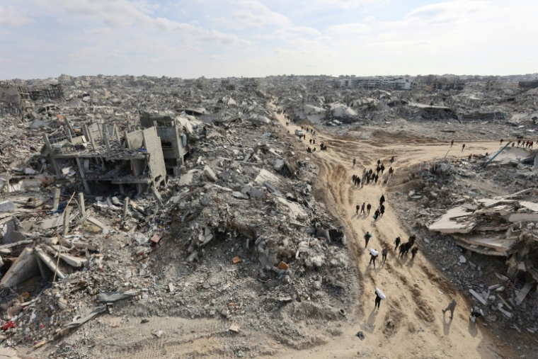 Cette vue aérienne montre des Palestiniens déplacés retournant au camp de réfugiés de Jabalia, dévasté par la guerre, dans le nord de la bande de Gaza, le 19 janvier 2025 ( AFP / Omar AL-QATTAA )