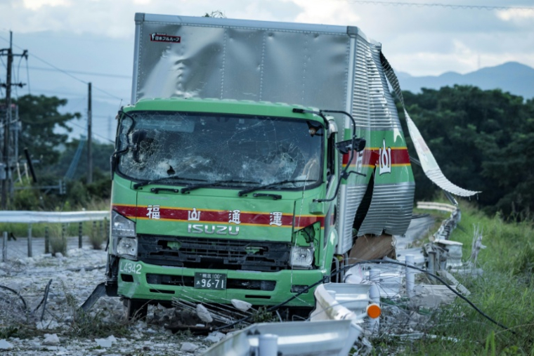 Un camion endommagé est laissé sur une route jonchée de débris à la suite d'une explosion survenue au centre commercial Aeon Mall à Kumamoto, à Kashima, dans le sud du Japon, le 29 juillet 2026, après qu'un tremblement de terre a frappé la région ( AFP / Yuichi YAMAZAKI )