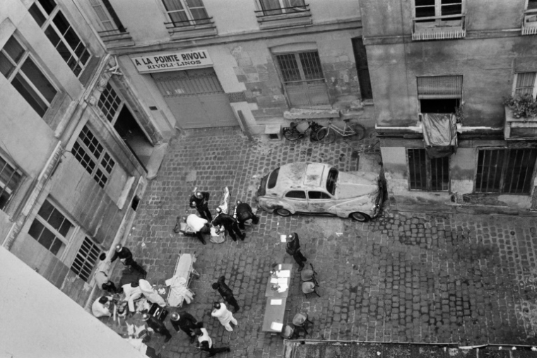 Des pompiers et des secouristes prennent en charge des blessés dans une cour de la rue des Rosiers, à Paris, après que le restaurant traiteur franco-juif Jo Goldenberg a été attaqué par des hommes armés, le 9 août 1982 ( AFP / Jacques DEMARTHON )