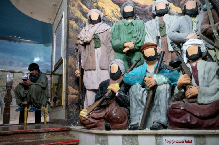 Un visiteur s'assoit près de statuettes représentant des moudjahidine sans visage au "musée du Jihad" dans la province d'Herat, en Afghanistan, le 6 janvier 2026 ( AFP / Wakil KOHSAR )