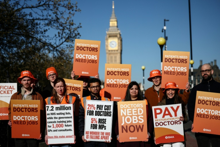 Des médecins résidents tiennent un piquet de grève devant l'hôpital St Thomas, dans le centre de Londres, le 7 avril 2026 ( AFP / Henry Nicholls )