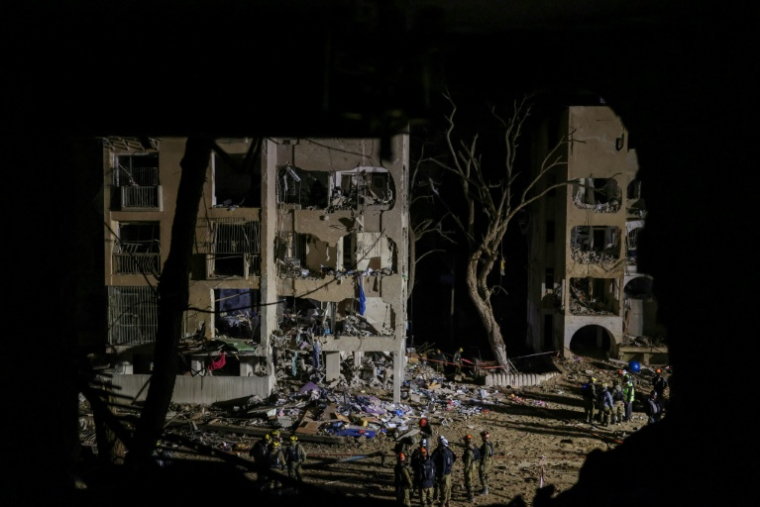 Des secouristes sur le lieu d'une frappe de missile iranien à Arad, en Israël, le 22 mars 2026 ( AFP / Ilia YEFIMOVICH )