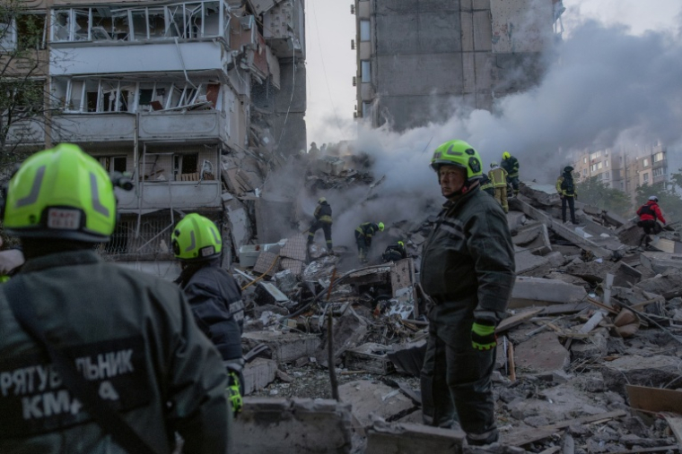 Les secouristes dans les ruines d'un immeuble détruit par une frappe russe à Kiev, le 14 mai 2026 ( AFP / Roman PILIPEY )