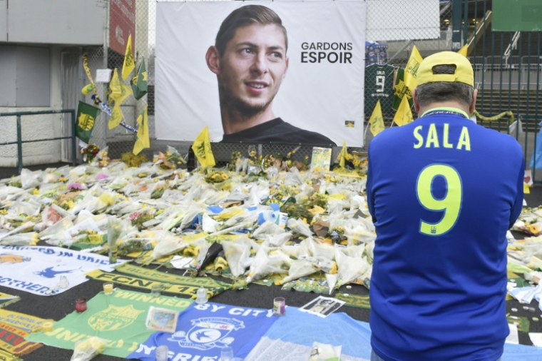 Un portrait géant de l'attaquant argentin Emiliano Sala et des fleurs devant le stade de La Beaujoire à Nantes, le 5 février 2019, quelques jours après son décès ( AFP / Sebastien SALOM-GOMIS )