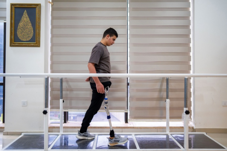 Zuhdi Abou Shanab, un adolescent palestinien de 17 ans qui a perdu sa jambe pendant la guerre à Gaza, s'entraîne à marcher avec une prothèse dans un centre médical où il reçoit des soins, à Amman, le 13 octobre 2026 ( AFP / George SAIF )