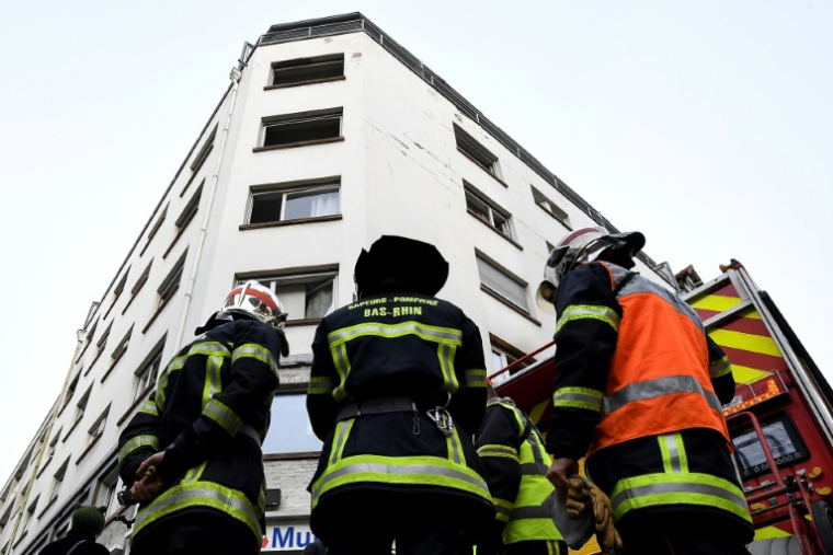Des pompiers devant un immeuble endommagé par un incendie, le 27 février 2020 à Strasbourg ( AFP / Patrick HERTZOG )