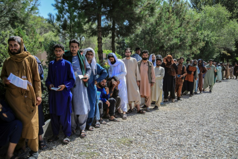 Des hommes afghans attendent de déposer leur dossier de candidature à un emploi au Qatar, dans la banlieue de Hérat, le 30 juillet 2025 ( AFP / Mohsen KARIMI )