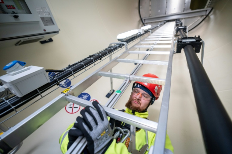 Le mineur Patryk Paja, participant à une formation à l'exploitation d'éoliennes, attend à l'intérieur du mât l'ascenseur qui le conduira à la nacelle de l'une des éoliennes du parc de Gorzyca, dans l'ouest de la Pologne, le 8 juillet 2026 ( AFP / Wojtek RADWANSKI )