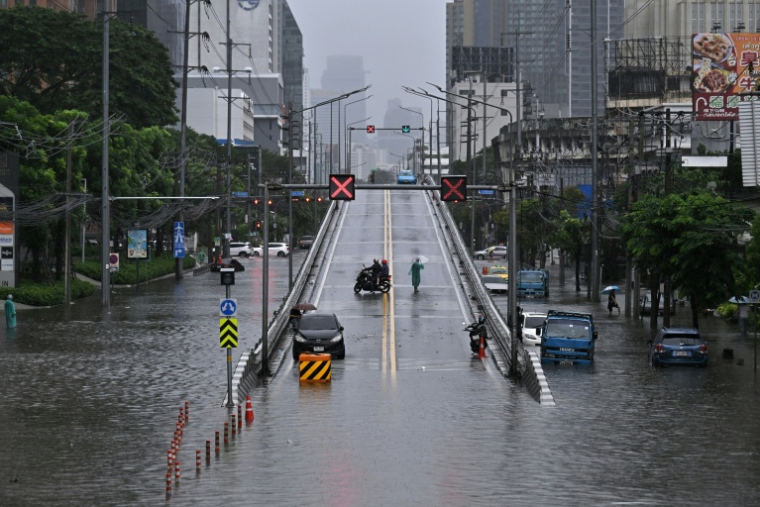 Des automobilistes font demi-tour sur un pont surplombant des eaux de crue le long de la route Phetchaburi à Bangkok, la capitale thaïlandaise, le 26 septembre 2026 ( AFP / Lillian SUWANRUMPHA )