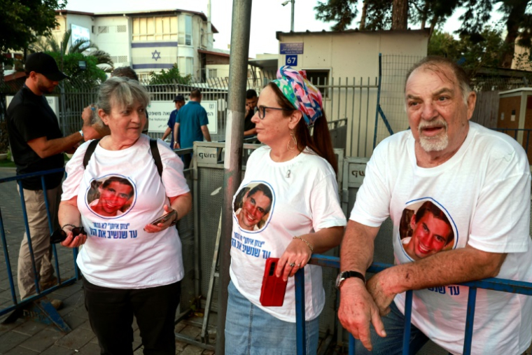 Des Israéliens portant des T-shirt avec la photo de l'officier Hadar Goldin tué en 2014 à Gaza attendent l'arrivée d'un corps rendu par le Hamas et présumé être le sien devant les services de médecine légiste de Tel Aviv, le 9 novembre 2025 ( AFP / Menahem Kahana )