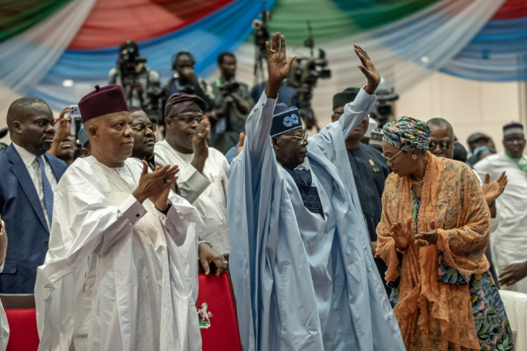 Le vice-président du Nigeria, Kashim Shettima (g), félicite le président nigérian Bola Ahmed Tinubu (c) après sa victoire à la primaire présidentielle du parti All Progressives Congress (APC), au Centre de conférences international Bola Ahmed Tinubu, le 24 mai 2026 à Abuja ( AFP / Light Oriye Tamunotonye )