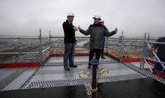Le président français Emmanuel Macron écoute les explications au sommet de la flèche de la cathédrale Notre-Dame de Paris