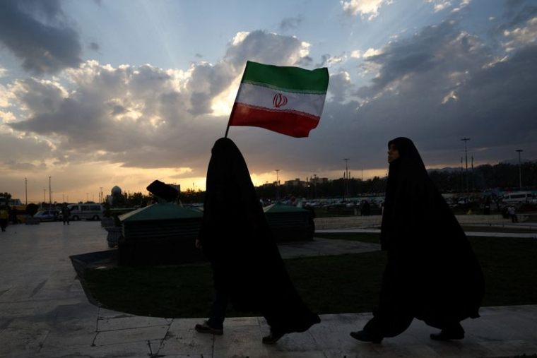 Une Iranienne brandit le drapeau iranien lors d'un rassemblement à Téhéran.