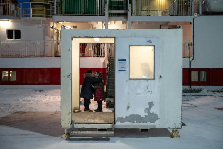 Des femmes inuites se disent au revoir derrière le comptoir d'enregistrement avant que l'une d'entre elles embarque à bord du ferry Sarfaq Ittuk, au port de Nuuk, au Groenland, le 13 mars 2026 ( AFP / Florent VERGNES )