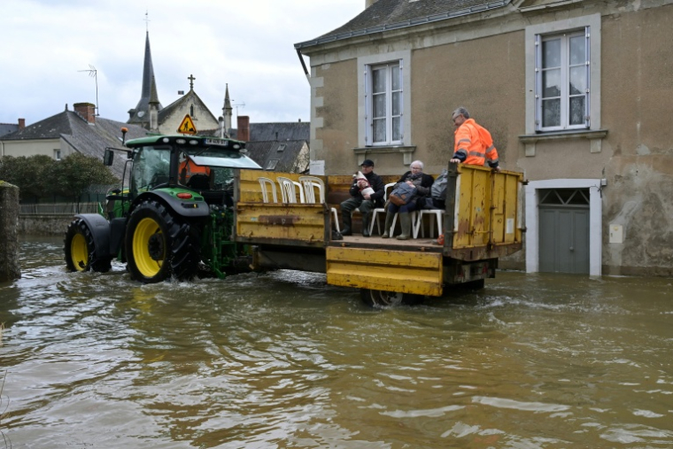 Des personnes sont évacuées de leur domicile en raison des inondations, le 20 février 2026 à Cheffes, dans le Maine-et-Loire ( AFP / Damien MEYER )