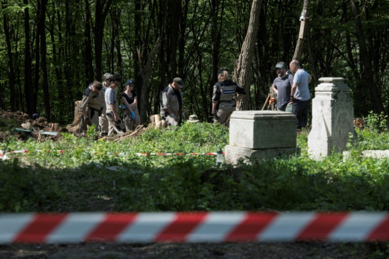 Des archéologues polonais travaillent sur le site d'exhumation du massacre de Volhynie de la Seconde Guerre mondiale, près du village détruit de Puzniki, dans la région de Ternopil, le 25 avril 2025 en Ukraine ( AFP / Vladyslav Musiienko )