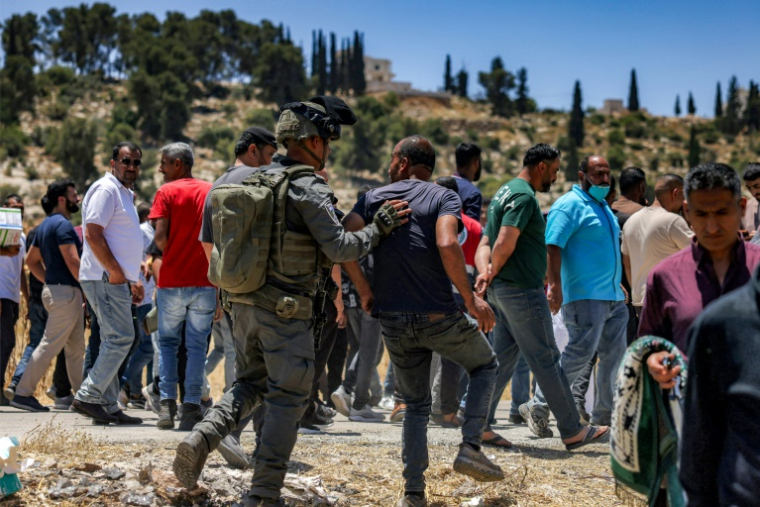 Les forces de sécurité israéliennes tentent de disperser des Palestiniens rassemblés pour protester contre les incendies de terres signalés par des colons israéliens dans le village palestinien d'Idna, à l'ouest d'Hébron, en Cisjordanie occupée, Le 5 juin 2026 ( AFP / HAZEM BADER )