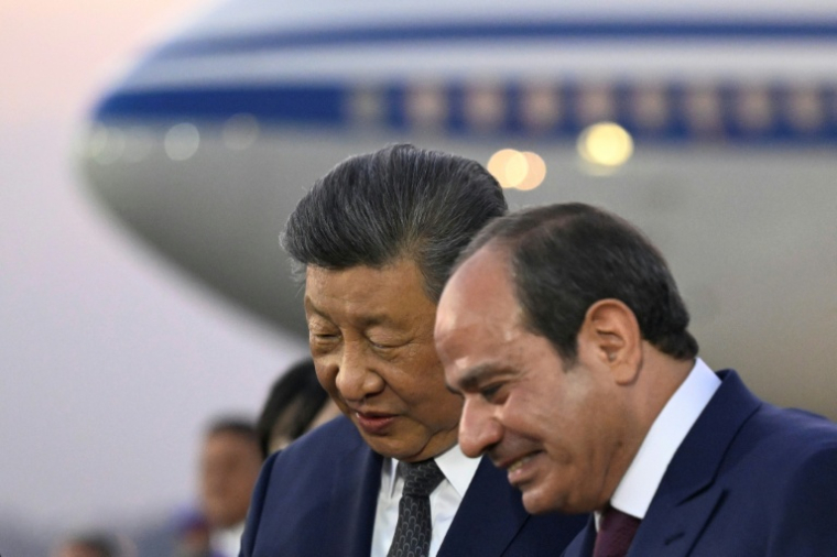 Le président chinois Xi Jinping (g) écoute son homologue égyptien Abdel Fattah al-Sissi à son arrivée sur le tarmac de l'aéroport international du Caire, le 1er septembre 2026 ( POOL / Khaled DESOUKI )