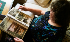 Blaza Cedilnik regarde des photos de son père, l'un des 15.000 "collabos" slovènes brutalement exécutés après-guerre, le 30 avril 2025 à Ljubljana, en Slovénie ( AFP / Jure Makovec )